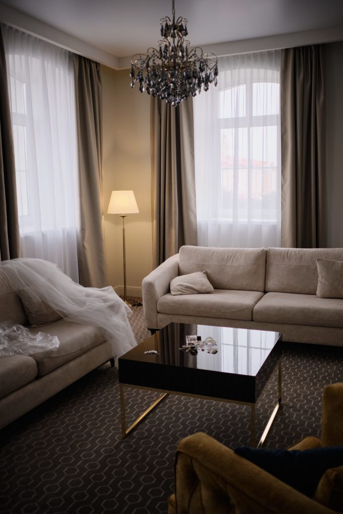 A modern living room featuring elegant chandeliers, sofas, and a coffee table.